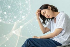 肩こりに悩む20代の日本人女性。自律神経の乱れによる不調をイメージしたヘルスケア写真