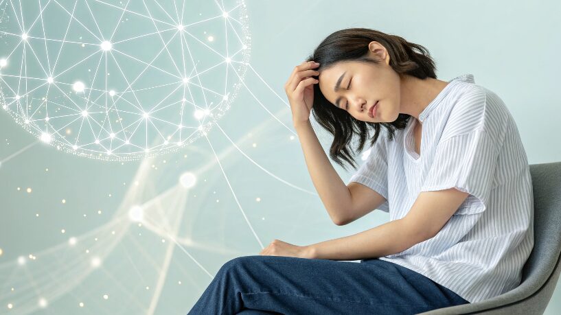 肩こりに悩む20代の日本人女性。自律神経の乱れによる不調をイメージしたヘルスケア写真